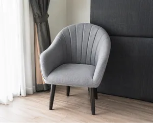 Grey upholstered accent chair in a room, used as a background removal sample